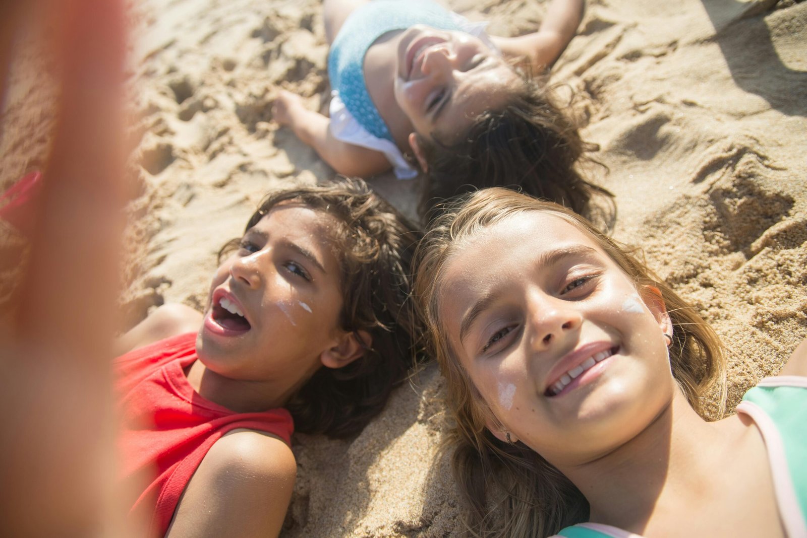A group of joyful children having fun at the beach during summer, enjoying a sunny day together.